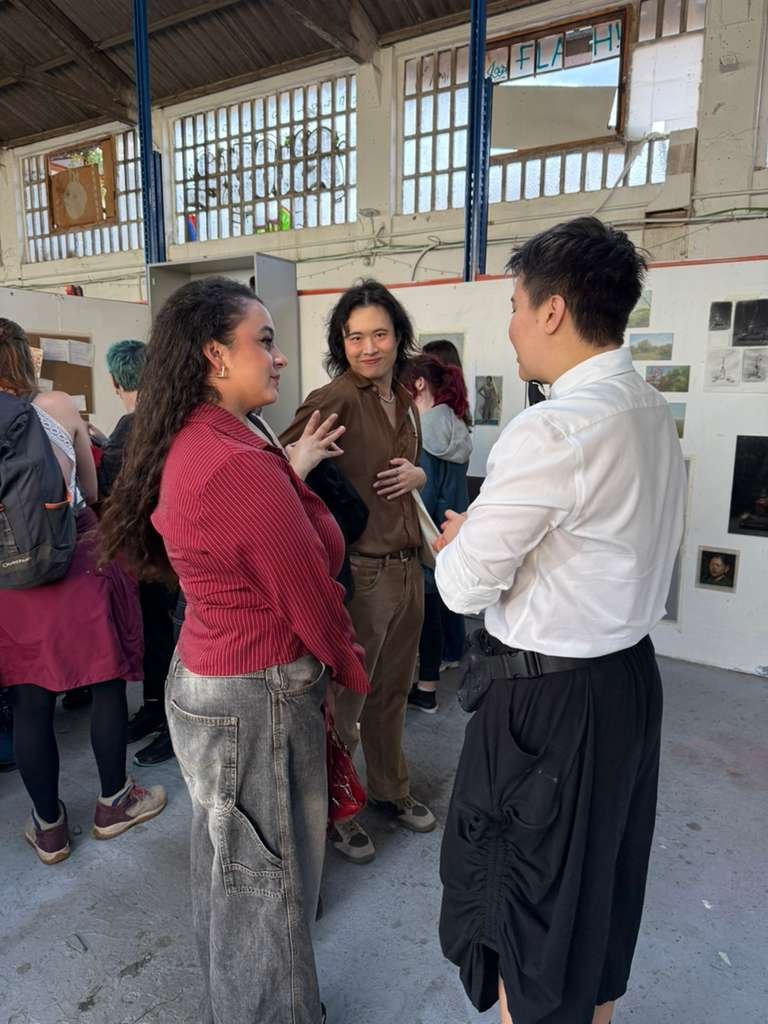 Gallery visitors examining classical technique oil paintings at artist's open studio