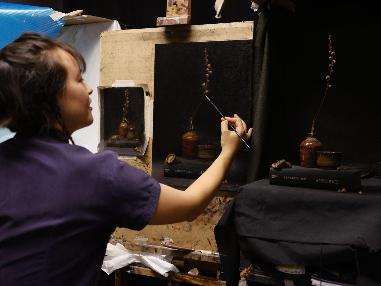 T. Cheung-Damonte painting in Barcelona studio, demonstrating classical oil painting techniques with natural lighting and traditional artist tools